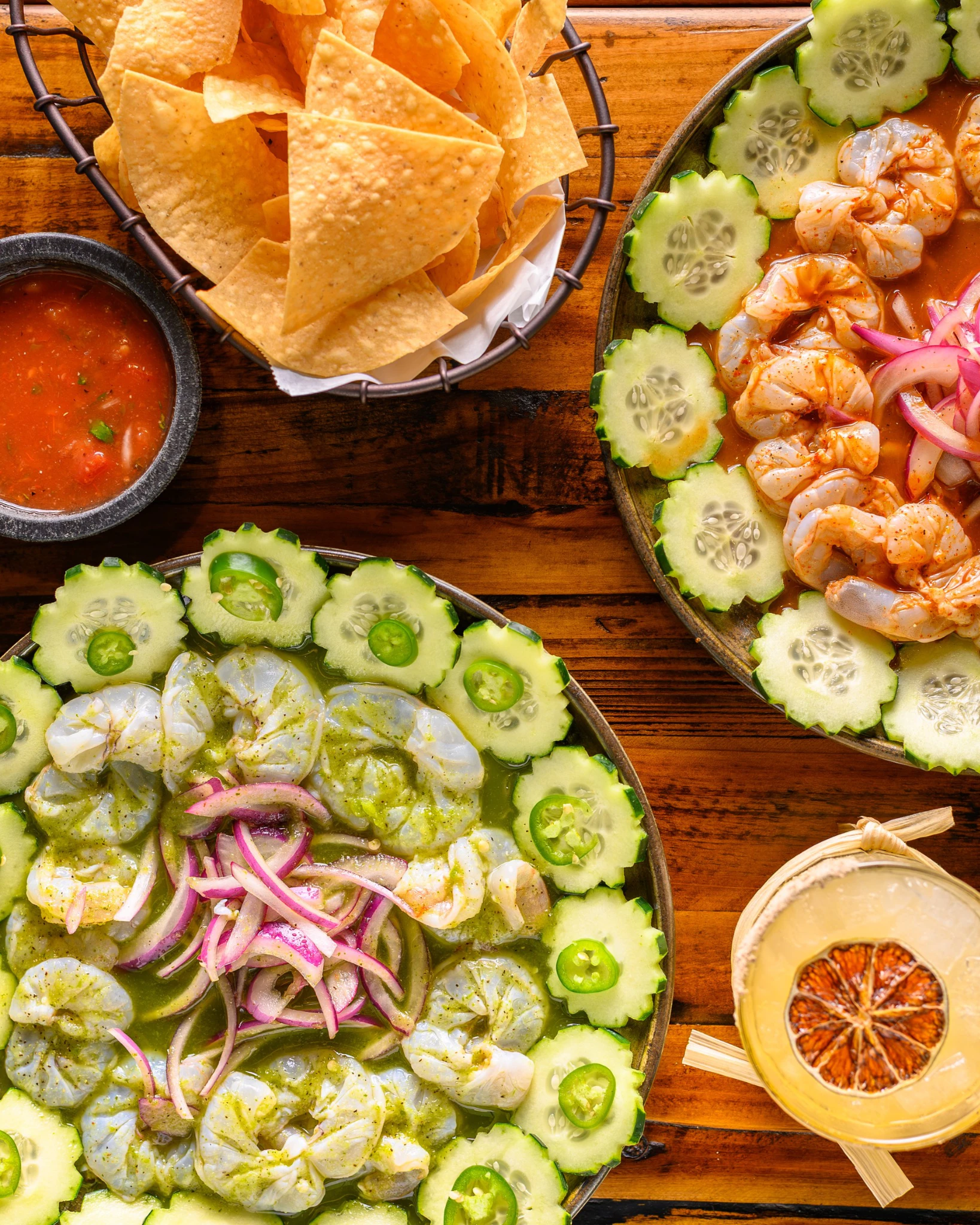 Green and red aguachiles with shrimp, cucumber, red onion, jalapeño, chips, and salsa