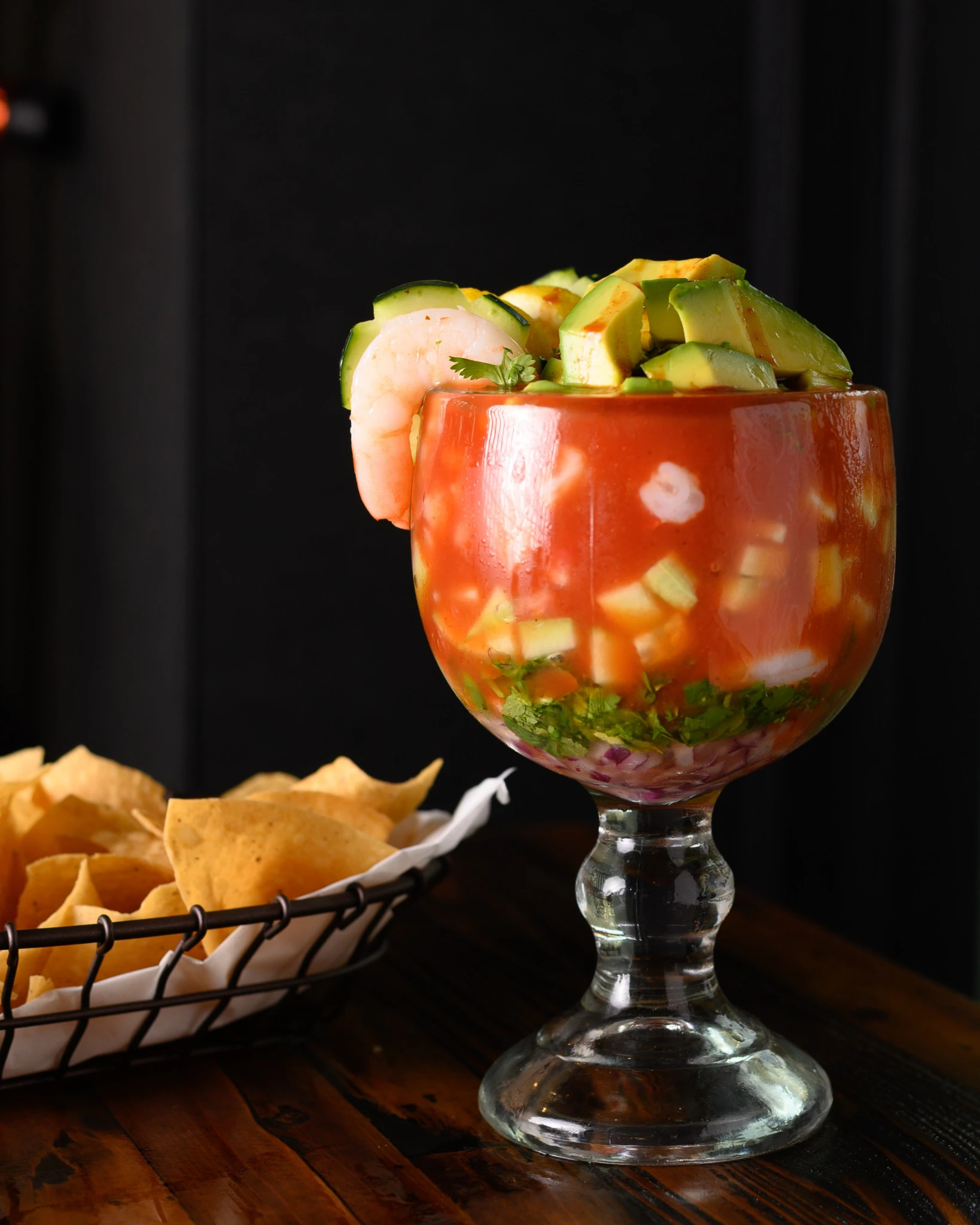 Cóctel de Camarón topped with avocado, cucumber, and shrimp, served with tortilla chips